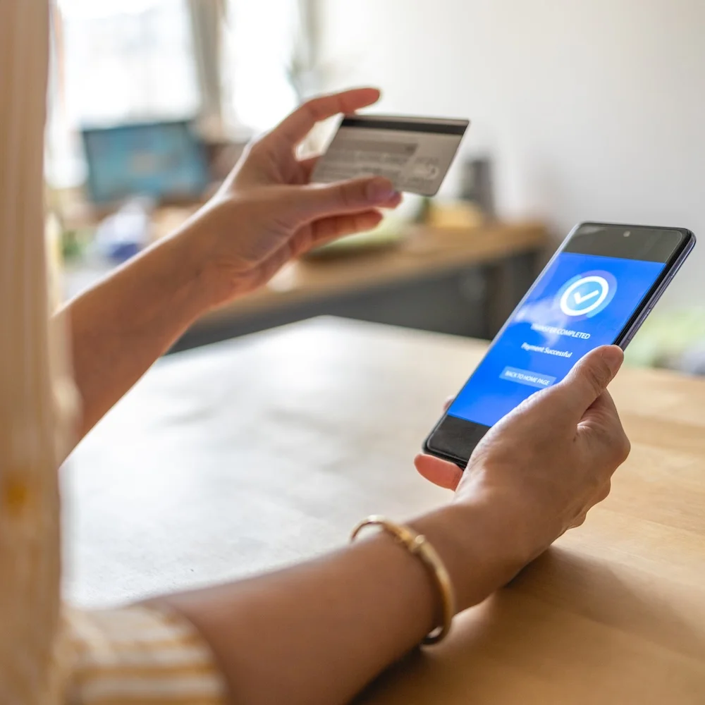 young-woman-paying-bills-with-mobile-phone
